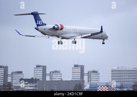 SAS Scandinavian Airlines Bombardier Mitsubishi CRJ-900 tel qu'il a été vu voler sur l'approche finale pour l'atterrissage à l'aéroport d'Amsterdam Schiphol AMS EHAM dans une soirée nuageux devant le terminal de l'aéroport et la tour de contrôle. L'avion régional à corps étroit a l'enregistrement EI-FPV et le nom Trud Viking. SAS est le porte-drapeau du Danemark, de la Norvège et de la Suède. Le nom est une abréviation de Scandinavian Airlines System. La compagnie aérienne compte 180 appareils et est membre du groupe d'aviation Star Alliance. L'industrie de l'aviation et le trafic de passagers sont en phase avec la Covid-19 co Banque D'Images