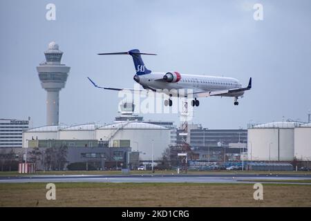 SAS Scandinavian Airlines Bombardier Mitsubishi CRJ-900 tel qu'il a été vu voler sur l'approche finale pour l'atterrissage à l'aéroport d'Amsterdam Schiphol AMS EHAM dans une soirée nuageux devant le terminal de l'aéroport et la tour de contrôle. L'avion régional à corps étroit a l'enregistrement EI-FPV et le nom Trud Viking. SAS est le porte-drapeau du Danemark, de la Norvège et de la Suède. Le nom est une abréviation de Scandinavian Airlines System. La compagnie aérienne compte 180 appareils et est membre du groupe d'aviation Star Alliance. L'industrie de l'aviation et le trafic de passagers sont en phase avec la Covid-19 co Banque D'Images