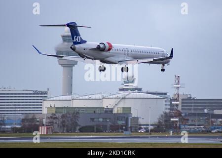 SAS Scandinavian Airlines Bombardier Mitsubishi CRJ-900 tel qu'il a été vu voler sur l'approche finale pour l'atterrissage à l'aéroport d'Amsterdam Schiphol AMS EHAM dans une soirée nuageux devant le terminal de l'aéroport et la tour de contrôle. L'avion régional à corps étroit a l'enregistrement EI-FPV et le nom Trud Viking. SAS est le porte-drapeau du Danemark, de la Norvège et de la Suède. Le nom est une abréviation de Scandinavian Airlines System. La compagnie aérienne compte 180 appareils et est membre du groupe d'aviation Star Alliance. L'industrie de l'aviation et le trafic de passagers sont en phase avec la Covid-19 co Banque D'Images