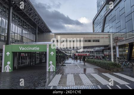 Une bannière indiquant aux gens la direction du centre de vaccination au centre d'exposition et de congrès de la RAI. La vie quotidienne pendant le confinement à la quatrième vague de la pandémie. Les habitants et quelques touristes dans les rues calmes d'Amsterdam pendant le confinement dans la capitale néerlandaise avec des magasins et des magasins paraissant avec fermé avec le roller métal volet vers le bas, cafés, bars et restaurants également fermés avec des tables et des chaises des terrasses fermées. Les pays-Bas ont été la première nation européenne à déclarer un verrouillage complet pour lutter contre la nouvelle variante d'Omicron qui s'intensifie. Après un gouvernement soudain Banque D'Images