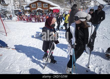 Deux skieurs iraniens de sexe féminin, dont l'un porte un masque protecteur, se trouvent au bas d'une pente dans la station de ski Darbandsar, à 67Km (42 miles) au nord-est de Téhéran, sur 28 janvier 2022. Malgré la prévalence de la variante Omicron de la nouvelle coronavirus (COVID-19) en Iran, La ville de Téhéran n'est toujours pas dans une situation rouge (à haut risque) et les gens peuvent encore s'amuser et skier sur les pistes de ski. Mais selon le dernier rapport de l'Agence de presse métropolitaine d'Iran (IMNA), dans la nouvelle situation de la prévalence de la variation Omicron de Covid-19 en Iran, Province de Qom qui est le voisin de Banque D'Images