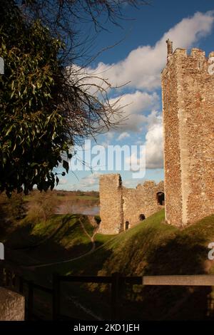 Le château de Framingham, Royaume-Uni avec des arbres qui donnent sur le lac dans la vallée sous le ciel bleu Banque D'Images
