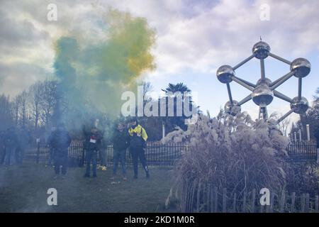 Les manifestants ont incendié des cartouches de fumée bleues et jaunes devant l'Atomium. Protestation contre le gouvernement et les mesures de la COVID dans la capitale belge, Bruxelles. Les manifestants ont traversé la ville de la gare du Nord vers l'Atomium, symbole et point de repère de la ville à travers le quartier de Laeken. Selon les médias locaux, seulement 1600 personnes se sont rassemblées ce dimanche. La manifestation a appelé à la suppression du gouvernement belge en raison des mesures pandémiques de Covid, comme la vaccination obligatoire, le Covid Health Pass, le code QR, les masques faciaux, le téléphone cellulaire 5G etc. La police Banque D'Images