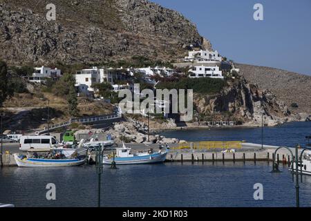 Scène du port de l'île avec quelques petits bateaux amarrés. Livadia, le port et le village principal de l'île de Tilos avec les maisons à l'architecture traditionnelle blanchie à la chaux et la plage avec l'eau de mer cristalline. Telos est une petite île grecque méditerranéenne située dans la partie de la mer Égée des îles Dodécanèse avec une population de 780 habitants près de la côte turque. Fin 2018, Tilos est devenue la première île de la Méditerranée à fonctionner exclusivement sur l'énergie éolienne et solaire, une île verte autosuffisante, une initiative financée par l'UE pour l'énergie verte provenant de sources renouvelables protégeant le natu Banque D'Images