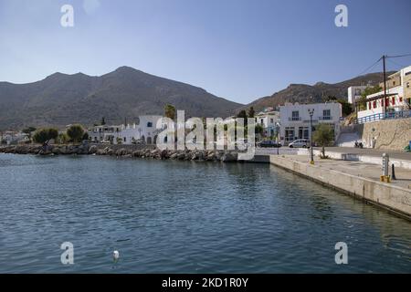 Scène du port de l'île avec quelques petits bateaux amarrés. Livadia, le port et le village principal de l'île de Tilos avec les maisons à l'architecture traditionnelle blanchie à la chaux et la plage avec l'eau de mer cristalline. Telos est une petite île grecque méditerranéenne située dans la partie de la mer Égée des îles Dodécanèse avec une population de 780 habitants près de la côte turque. Fin 2018, Tilos est devenue la première île de la Méditerranée à fonctionner exclusivement sur l'énergie éolienne et solaire, une île verte autosuffisante, une initiative financée par l'UE pour l'énergie verte provenant de sources renouvelables protégeant le natu Banque D'Images