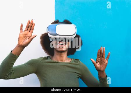 Jeune femme africaine s'amusant avec des lunettes futuristes de réalité virtuelle - concept Metaverse Banque D'Images