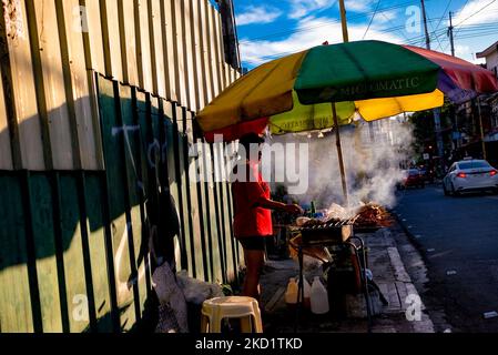 Un propriétaire de cabine de barbecue attend les clients le long d'une rue animée de la ville de Makati, le métro de Manille, Philippines sur 4 février 2022. Depuis le début du mois de février, les autorités ont déclassé les restrictions de quarantaine dans la région métropolitaine de Manille, ainsi que dans quelques autres provinces, après avoir constaté une baisse du nombre de COVID19 cas dans le pays. (Photo de George Calvelo/NurPhoto) Banque D'Images