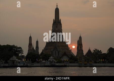 Le soleil se couche derrière la stupa du temple bouddhiste Wat Arun ou le 'Temple de l'Aube' vu de l'autre côté des rives de la rivière Chao Phraya à Bangkok, Thaïlande, 05 février 2022. (Photo par Anusak Laowilas/NurPhoto) Banque D'Images