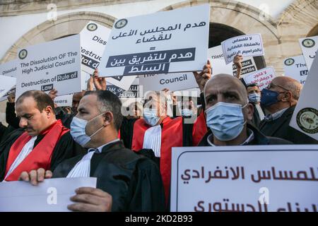 Les juges tunisiens portant des robes de chambre, élèvent des placards qui lisent en arabe, la destruction du Conseil judiciaire suprême est une destruction de la séparation entre les pouvoirs, lors d'une manifestation organisée à l'initiative de l'Association des juges tunisiens (AMT) en dehors du bâtiment du Tribunal (Également appelé le Palais de justice) à Tunis, en Tunisie, sur 10 février 2022, pour protester contre la décision du président Kais Saied de dissoudre le Conseil judiciaire suprême du comté ainsi que contre la fermeture de son siège par les autorités tunisiennes. Des manifestants ont également appelé Banque D'Images