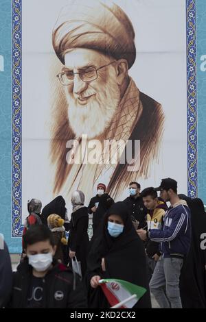 Le peuple iranien est sous un portrait géant du Guide suprême iranien, l’ayatollah Ali Khamenei, sur la place Azadi (liberté) à l’ouest de Téhéran, lors d’un rassemblement pour marquer 43rd ans de victoire de la révolution islamique iranienne de 1979, au milieu du déclenchement de la variante Omicron du COVID-19 en Iran. Sur 11 février 2022. L'Iran connaît une nouvelle fois une augmentation du nombre de personnes infectées par le COVID-19 par la propagation de la variante Omicron. (Photo de Morteza Nikoubazl/NurPhoto) Banque D'Images