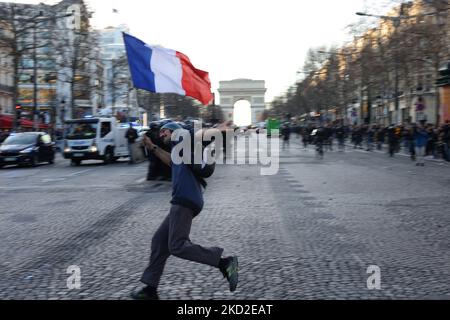 Les démonstrateurs branlent des drapeaux français et des gilets jaunes sur les champs-Elysées à Paris sur 12 février 2022 alors que des convois de manifestants appelés « Convoi de la liberté » sont arrivés dans la capitale française. Des milliers de manifestants dans des convois, inspirés par des camionneurs canadiens paralysant la circulation frontalière avec les États-Unis, se rendaient à Paris depuis toute la France sur 11 février, certains espérant bloquer la capitale en opposition aux restrictions de Covid-19 malgré les avertissements de la police de reculer. Les manifestants comprennent de nombreux activistes anti-Covid pour la vaccination, mais aussi des personnes qui protestent contre la hausse rapide des prix de l'énergie que le Banque D'Images