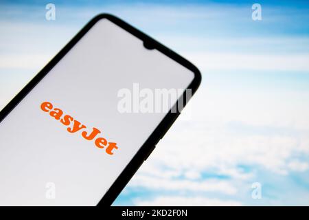 Dans cette illustration, un logo EasyJet Airlines apparaît sur l'écran d'un smartphone avec un papier peint d'ordinateur en arrière-plan à Athènes, Grèce sur 12 février 2022. (Photo d'illustration par Nikolas Kokovlis/NurPhoto) Banque D'Images