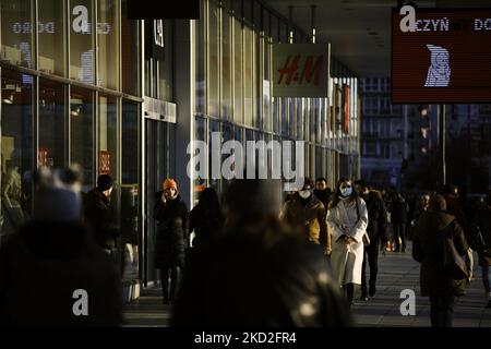 Un couple portant un masque facial est vu près d'un boulevard commerçant dans le centre de Varsovie, Pologne, le 12 février 2022. Le ministre de la Santé, Adam Niedzielski, a annoncé cette semaine la fin de la pandémie COVID-19 en Pologne. Niedzielski a également annoncé la levée des restrictions en mars à condition que le nombre de nouveaux cas continue de diminuer au rythme actuel. Les nouvelles du ministère de la Santé défie les statistiques actuelles qui montrent que la Pologne a l'un des taux de mortalité excédentaires les plus élevés d'Europe et une stagnation des taux de vaccination. (Photo par STR/NurPhoto) Banque D'Images