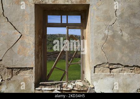 Vue sur les champs à travers une fenêtre cassée dans une maison en ruines dans le village abandonné de Souskiou. Chypre, dimanche, 20 février 2022. C'est un petit village, dont la partie principale était les Chypriotes turcs. En 1958, peu de Chypriotes grecs ont quitté le village en raison de l'escalade du conflit avec la communauté turque. Et en 1974, les Chypriotes turcs restants migrent vers le Nord. (Photo de Danil Shamkin/NurPhoto) Banque D'Images