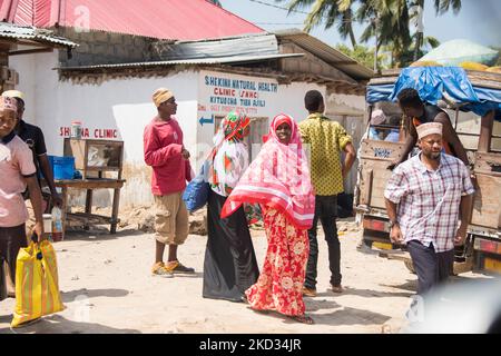 Zanzibar, Tanzanie - 01 mai,2022: Vue sur la rue de la vie quotidienne habituelle des gens de tous les âges se tenant le long de la route sur l'île de Zanzibar. Banque D'Images