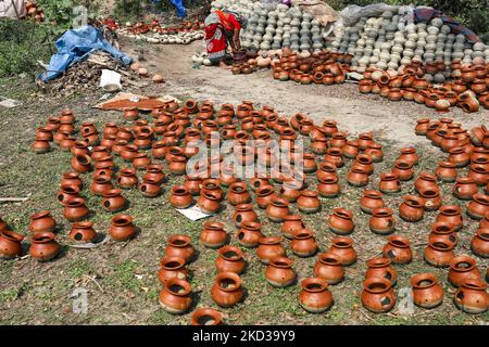 Une femelle potier arrange des ustensiles faits de boue d'argile pour sécher au soleil à Kumar Para (communauté de potters) dans la banlieue de Munshigonj de Dhaka, au Bangladesh sur 22 février 2022. (Photo de Kazi Salahuddin Razu/NurPhoto) Banque D'Images