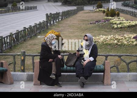 Deux femmes iraniennes sont assises sur un banc dans le parc Mellat (nation) du nord de Téhéran alors que l'une d'entre elles utilise son smartphone, 23 février 2022. Plusieurs députés ont souligné, lors d'une réunion publique sur 23 février, que le projet d'organisation des services du cyberespace n'est pas de bloquer l'espace virtuel, alors que selon l'ISNA, les membres de la commission pour la protection des droits des utilisateurs dans le cyberespace, réunis aujourd'hui par 18 voix, ont approuvé le projet de loi. (Photo de Morteza Nikoubazl/NurPhoto) Banque D'Images