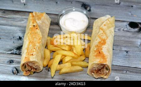 Recettes syriennes cuisine fond, poulet shawerma ou châtarma tortilla envelopper avec oignon, tomate, laitue et sauce à l'ail dans du pain syrien avec potatoe Banque D'Images