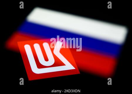 Le logo Lukoil affiché sur l'écran du téléphone et le drapeau russe affiché sur l'écran du téléphone sont visibles dans cette photo d'illustration à exposition multiple prise à Cracovie, en Pologne, sur 28 février 2022. (Photo d'illustration par Jakub Porzycki/NurPhoto) Banque D'Images