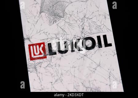 Le logo Lukoil affiché sur l'écran d'un téléphone est visible à travers un verre cassé dans cette photo d'illustration prise à Cracovie, Pologne sur 28 février 2022. (Photo d'illustration par Jakub Porzycki/NurPhoto) Banque D'Images