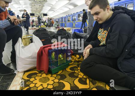 Un jeune homme avec son perroquet sur l'une des stations de métro utilisées comme abri à la bombe lors d'une menace de bombardement à Kiev, en Ukraine. 28 février 2022. (Photo de Maxym Marusenko/NurPhoto) Banque D'Images