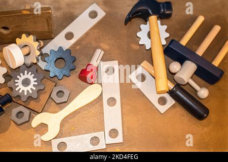 Jouet outils en bois y compris les engrenages et une clé et un marteau éparpillés sur une surface en bois - dessus couché Banque D'Images