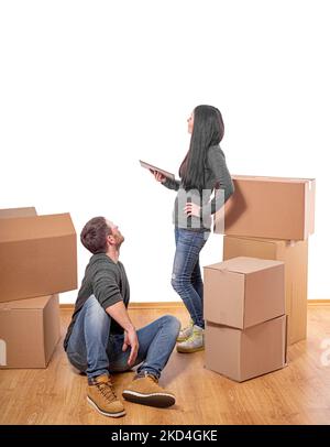 Jeune couple dans une nouvelle maison avec des boîtes en carton contre un mur. Banque D'Images