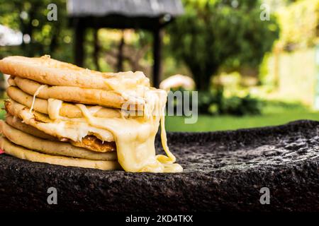 Plat salvadorien typique, marionnettes au fromage avec sauce au chou et à la tomate. Marionnettes au riz et au maïs farcies au fromage, aux haricots ou à d'autres ingrédients Banque D'Images