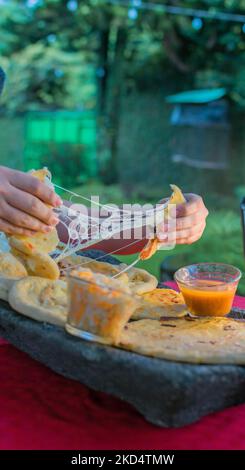 Plat salvadorien typique, marionnettes au fromage avec sauce au chou et à la tomate. Marionnettes au riz et au maïs farcies au fromage, aux haricots ou à d'autres ingrédients Banque D'Images