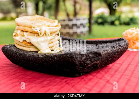 Plat salvadorien typique, marionnettes au fromage avec sauce au chou et à la tomate. Marionnettes au riz et au maïs farcies au fromage, aux haricots ou à d'autres ingrédients Banque D'Images