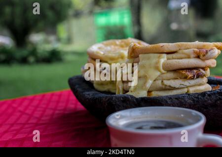 Plat salvadorien typique, marionnettes au fromage avec sauce au chou et à la tomate. Marionnettes au riz et au maïs farcies au fromage, aux haricots ou à d'autres ingrédients Banque D'Images