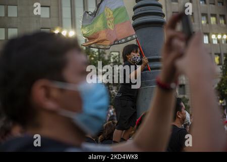 Un garçon porte un drapeau de la nation populaire mapuche, alors qu'il écoute le premier discours du nouveau président chilien Gabriel Boric, devant le palais présidentiel de la Moneda sur 11 mars 2022. Santiago, Chili. (Photo de Claudio Abarca Sandoval/NurPhoto) Banque D'Images