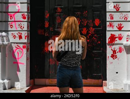 Une femme regarde le graffiti lié au féminisme et la porte d'entrée vandalisée de la Faculté de droit de l'Université dans le centre de San Cristobal de las Casas. Samedi, 12 mars 2022, à San Cristobal de las Casas, Chiapas, Mexique. (Photo par Artur Widak/NurPhoto) Banque D'Images