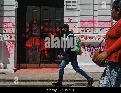 Les gens passent les graffitis liés au féminisme et la porte d'entrée vandalisée de la Faculté de droit de l'Université dans le centre de San Cristobal de las Casas. Samedi, 12 mars 2022, à San Cristobal de las Casas, Chiapas, Mexique. (Photo par Artur Widak/NurPhoto) Banque D'Images