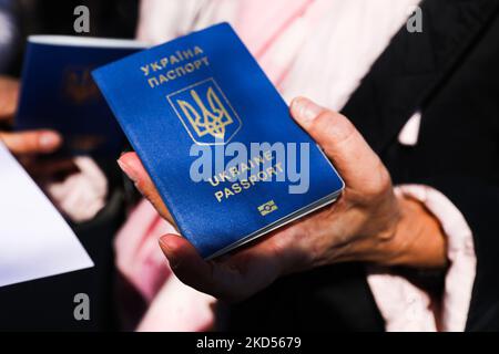 Le citoyen ukrainien arrivé à Cracovie après avoir fuit de l'Ukraine détient un passeport tout en restant dans une longue file d'attente pour traiter les formalités de son séjour dans l'UE au Consulat général d'Ukraine à Cracovie, Pologne sur 14 mars 2022. L'invasion russe en Ukraine provoque un exode massif de réfugiés vers la Pologne. (Photo de Beata Zawrzel/NurPhoto) Banque D'Images