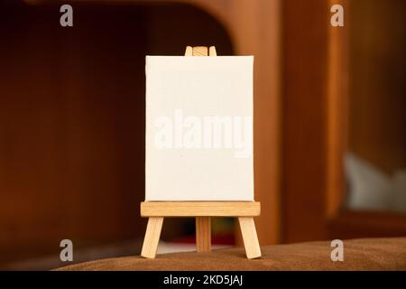 Une palette blanche vide se trouve sur un chevalet en bois sur une table sur fond marron, une palette et un espace pour le texte Banque D'Images