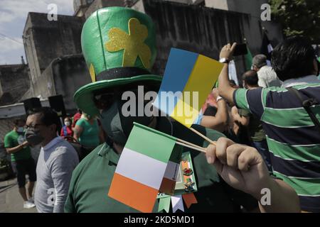 Une personne vêtue de vert et un drapeau ukrainien à l'extérieur de la paroisse de San Juan Bautista à Mexico, à l'occasion de la Saint Patrick, patron de l'Irlande. (Photo de Gerardo Vieyra/NurPhoto) Banque D'Images