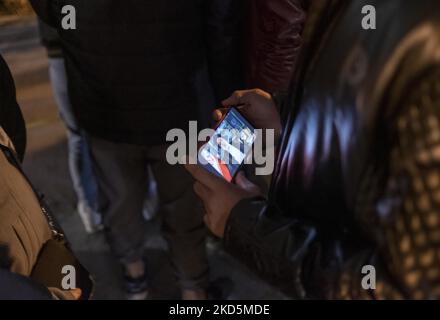 Une iranienne tient son smartphone tout en regardant le discours du président iranien Ebrahim Raisi du nouvel an, dans le parc aquatique et de pompiers du nord de Téhéran alors que le nouvel an iranien commence sur 20 mars 2022. (Photo de Morteza Nikoubazl/NurPhoto) Banque D'Images