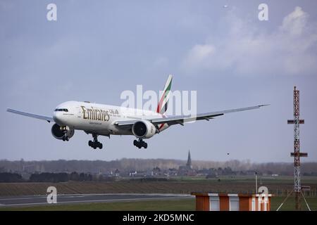 Emirates Boeing 777 comme vu voler et atterrir sur la piste avec la tour de contrôle et les nuages en arrière-plan. Emirates B777 avion comme vu sur l'approche finale vol, atterrissage et le roulement au sol à la capitale belge, l'aéroport de Bruxelles Zaventem BRU. Le Boeing Boeing 777-31HER, un avion de transport de passagers à gros corps moderne et avancé, est immatriculé A6-EQJ et est équipé de 2x GE90 moteurs à réaction. L'avion arrive à la ville européenne en provenance de Dubai DXB, Émirats Arabes Unis. Emirates est la plus grande compagnie aérienne et l'une des deux, porte-drapeau des Émirats arabes Unis. L'industrie de l'aviation et le trafic de passagers Banque D'Images