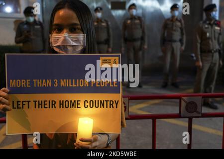 Les activistes thaïlandais placards contre l'invasion de l'Ukraine par la Russie alors qu'ils tiennent une veillée aux chandelles, lors d'une manifestation pacifique devant l'ambassade de Russie à Bangkok, Thaïlande, 23 mars 2022. (Photo par Anusak Laowilas/NurPhoto) Banque D'Images