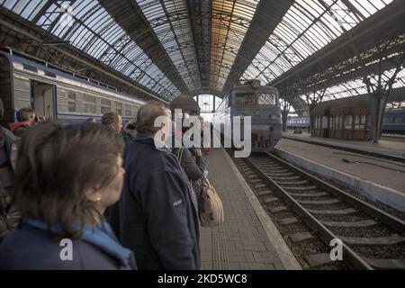 Les gens attendent le train. Quand le train arrive, ils se déplacent rapidement pour monter dans le train et avec un peu de panique pendant qu'ils sont à l'embarquement car ils ont peur d'un possible bombardement. Les Ukrainiens, principalement des femmes, des mères avec des enfants ou des personnes âgées, les réfugiés de guerre comme vu à bord de la voiture de chemin de fer, ils arrivent rapidement après avoir attendu le métro à la gare de Lviv passant le train pour arriver et monter sur les wagons rapidement que la gare est considérée comme une cible militaire. Le train va traverser les frontières ukrainiennes polonaises et aller plus loin en Pologne et dans d'autres pays européens. Sur Marc Banque D'Images