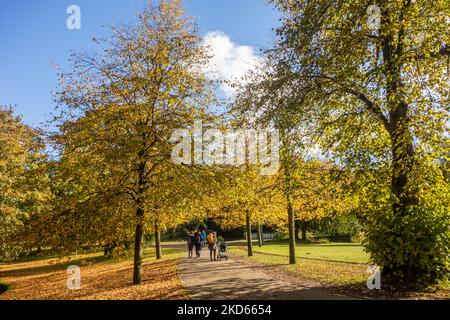 Personnes et familles bénéficiant du soleil d'automne dans les jardins du Pavillon dans la ville thermale de Derbyshire de Buxton dans le Peak District Banque D'Images