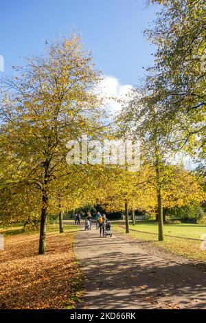 Personnes et familles bénéficiant du soleil d'automne dans les jardins du Pavillon dans la ville thermale de Derbyshire de Buxton dans le Peak District Banque D'Images