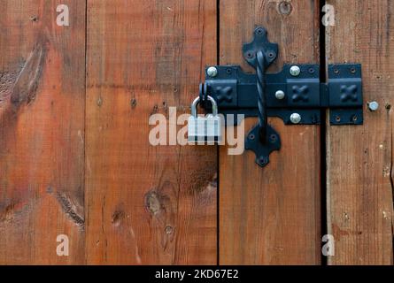 Cadenas en métal fermé, gros plan sur la porte en bois du loquet Banque D'Images