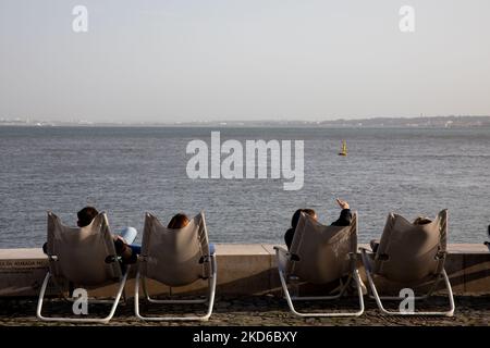 Les gens assistent au coucher du soleil sur la rive du Tage à Lisbonne, au Portugal, sur 29 mars 2022. (Photo de Manuel Romano/NurPhoto) Banque D'Images