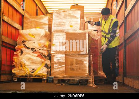 Un personnel de HGK ( RheinCargo GmbH) charge les marchandises en don dans un grand conteneur d'un camionneur dans un port de Niehl au parking de RheinCargo GmbH à Cologne, en Allemagne, sur 31 mars 2022, avant que les marchandises ne soient transportées par train à Kiev, en Ukraine. (Photo de Ying Tang/NurPhoto) Banque D'Images