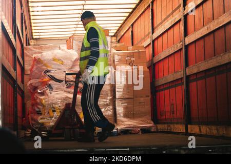 Un personnel de HGK ( RheinCargo GmbH) charge les marchandises en don dans un grand conteneur d'un camionneur dans un port de Niehl au parking de RheinCargo GmbH à Cologne, en Allemagne, sur 31 mars 2022, avant que les marchandises ne soient transportées par train à Kiev, en Ukraine. (Photo de Ying Tang/NurPhoto) Banque D'Images