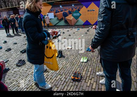 Le peuple ukrainien met des chaussures pour enfants sur le sol, dans le cadre d'une installation artistique ukrainienne pour attirer l'attention sur les meurtres de civils et en particulier d'enfants pendant la guerre en Ukraine. La Haye, sur 2 avril 2022. (Photo par Romy Arroyo Fernandez/NurPhoto) Banque D'Images