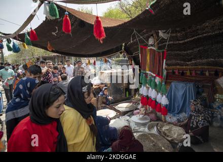 Dans un parc du nord de Téhéran, les familles marchent devant une tente indigène traditionnelle iranienne pendant le jour du Sizdah Bedar, également connu sous le nom de jour de la nature, sur 2 avril 2022. Sizdah Bedar, également connu sous le nom de la Journée de la nature, est un festival iranien qui se tient chaque année le treizième jour de Farvardin (le premier mois du calendrier iranien), où les gens passent du temps à l'extérieur et marquent la fin des vacances de Nowruz en Iran. Le gouvernement iranien a autorisé les gens à sortir de leur maison et à se rendre dans des lieux de plein air deux ans après la nouvelle épidémie de coronavirus (COVID-19) en Iran. (Photo de Morteza Nikoubazl/NurPhoto) Banque D'Images