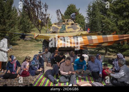 Une famille iranienne s'assoit devant un char militaire exposé par le musée de la Révolution et de la Défense sainte dans le nord de Téhéran pendant le jour de Sizdah Bedar, également connu sous le nom de la Journée de la nature, sur 2 avril 2022. Sizdah Bedar, également connu sous le nom de la Journée de la nature, est un festival iranien qui se tient chaque année le treizième jour de Farvardin (le premier mois du calendrier iranien), où les gens passent du temps à l'extérieur et marquent la fin des vacances de Nowruz en Iran. Le gouvernement iranien a autorisé les gens à sortir de leur maison et à se rendre dans des lieux de plein air deux ans après l'épidémie de la nouvelle coronavirus (COVID-19) Banque D'Images